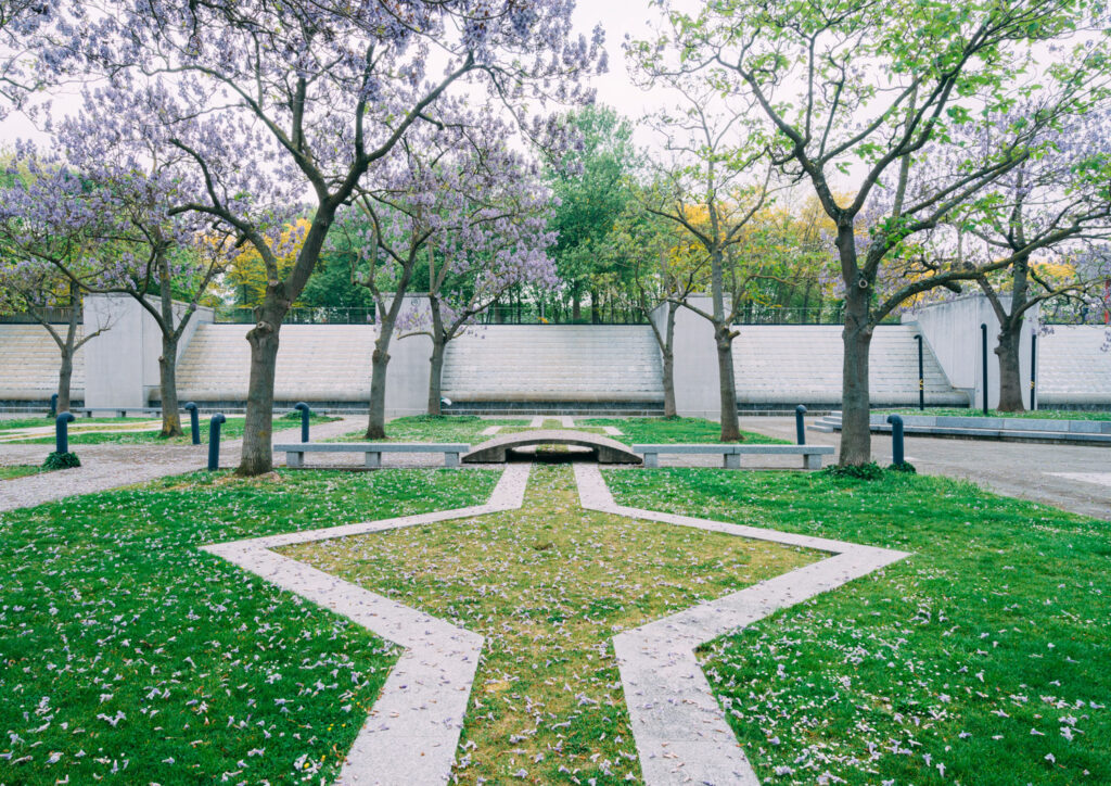 photo d'architecture représentant le parc de la villette, avec un sol graphique avec de l'herbe et des arbres en fleurs