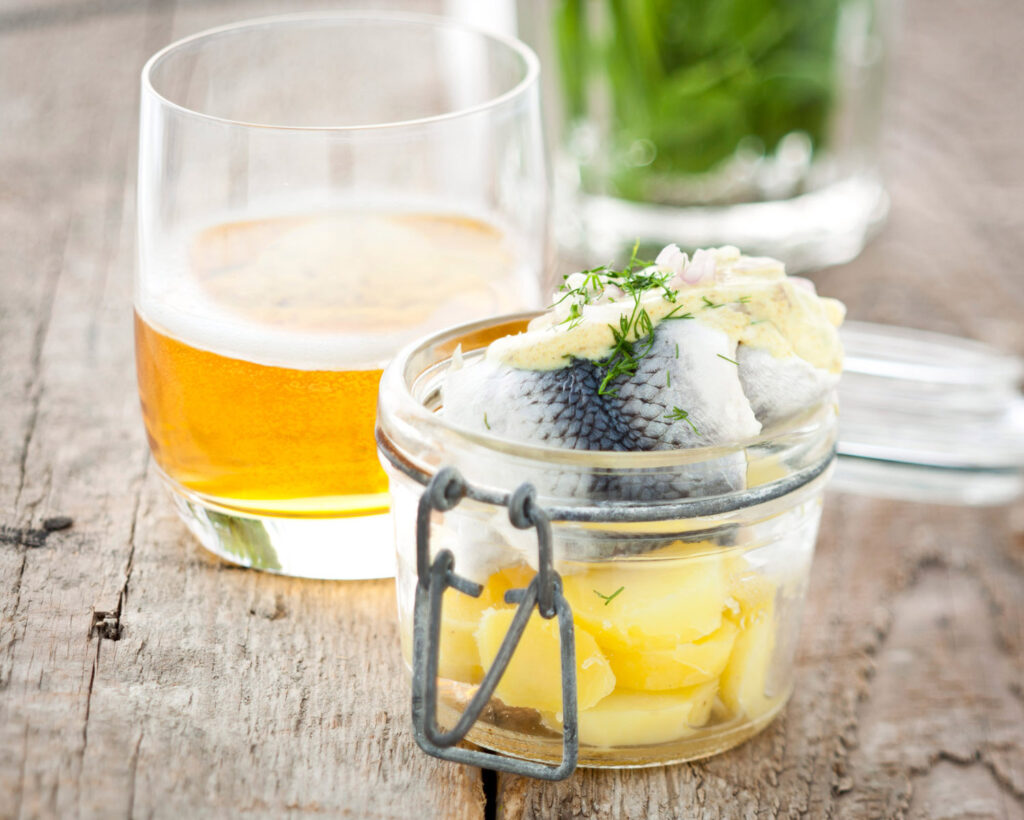 ambiance culinaire avec une entrée faite de hareng mariné et pomme de terre, avec un verre de cidre