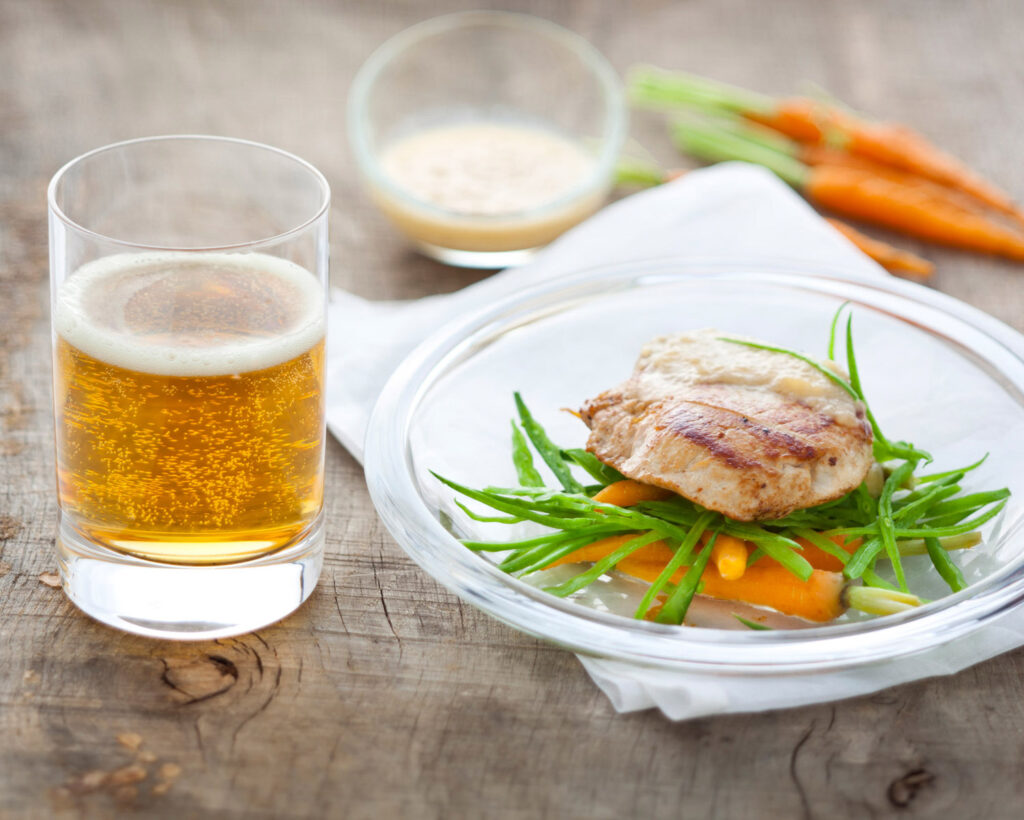 ambiance culinaire de plat, avec une escalope de poulet et des legumes, et un verre de cidre.