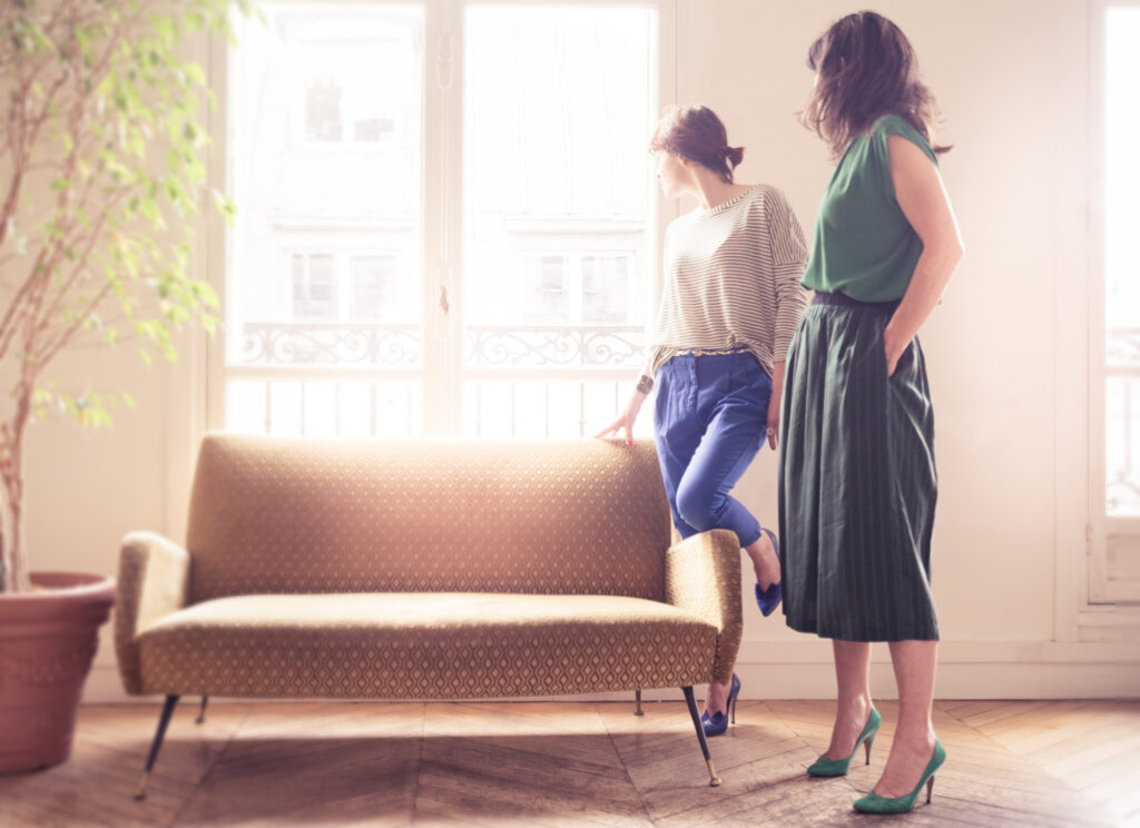 photos editorial de deux femmes se tenant devant une fenetre