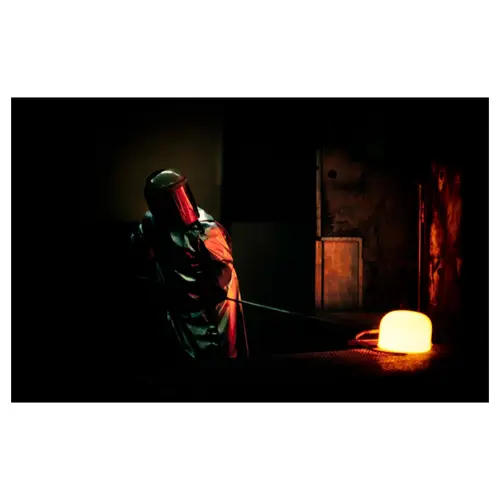 ouvrier au travail avec du métal en fusion, en combinaison aluminisée contre la chaleur