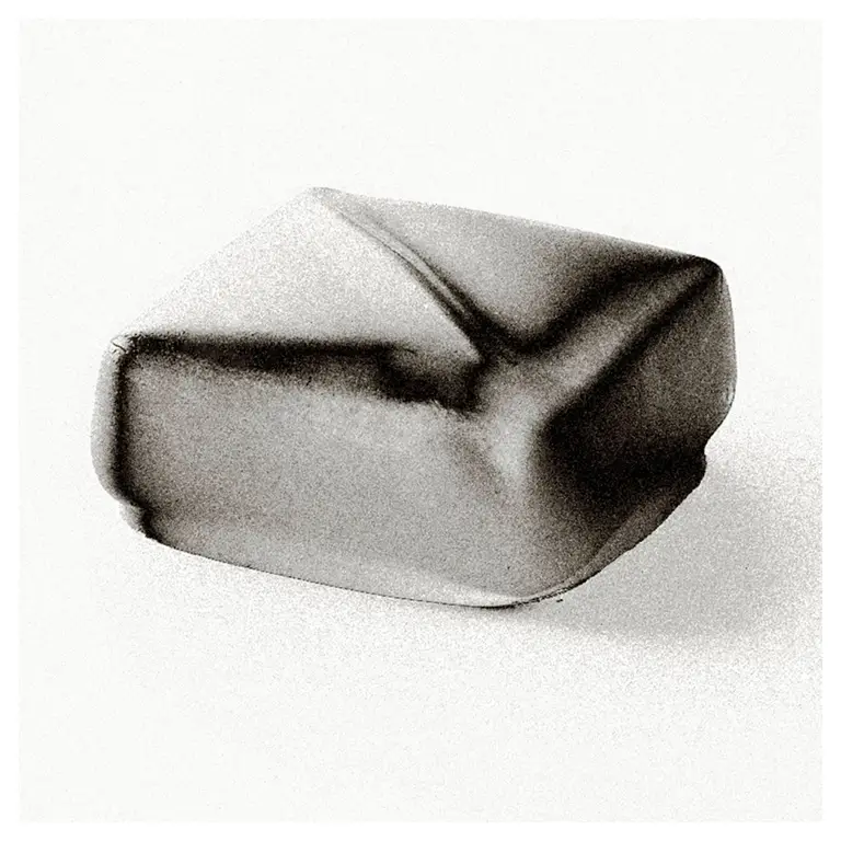 Cube de ganache chocolat noir, arêtes adoucies avec arête en V sur le dessus, rendu studio sur fond blanc, packshot culinaire pour fiche produit chocolatier.