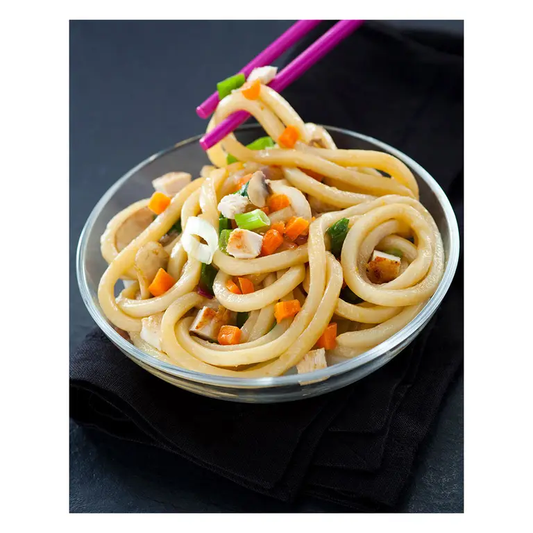 nouilles udon sautees au poulet et legumes prise aux baguettes