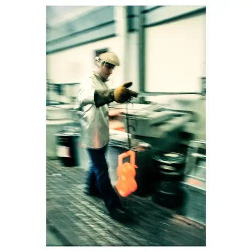 ouvrier dans une fonderie industrielle manipulant du métal en fusion, pour une pièce de moteur