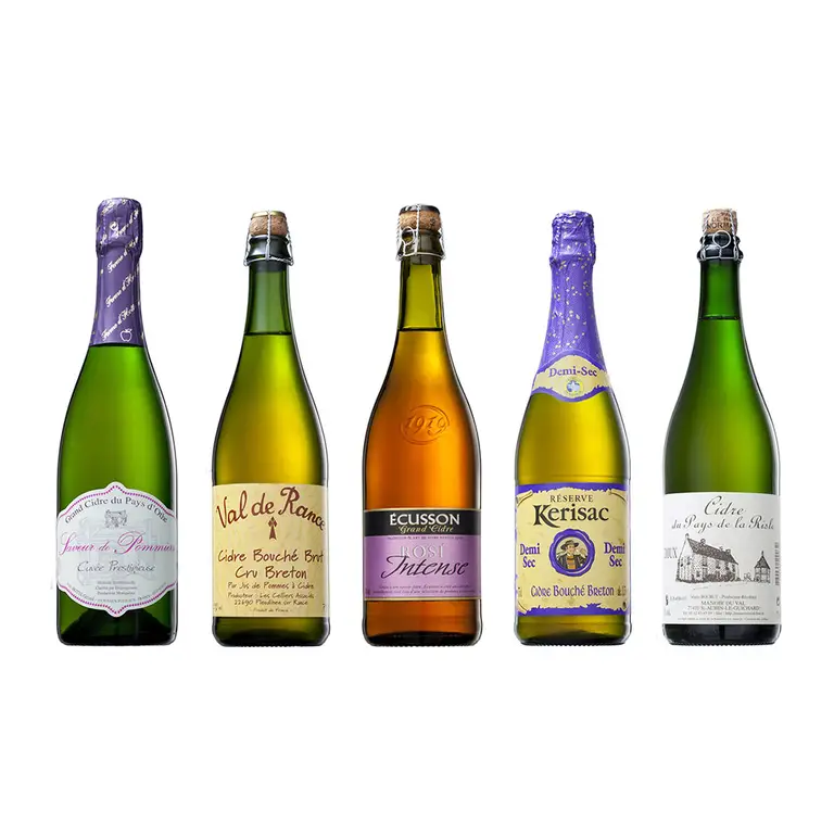 Assortiment de cinq bouteilles de cidre breton sur fond blanc pour une fiche produit en packshot photo.