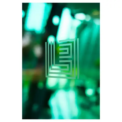 Logo en verre dépoli appliqué sur un panneau vitré vert, profondeur de champ courte, rendu corporate et minimaliste.