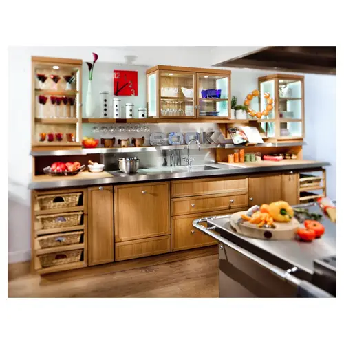 Vue d’ensemble d’une cuisine amenagée en bois et inox, plan de travail et rangements.