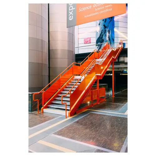 escalier moderne orange dans un intérieur industriel à la villette, vue de 3/4