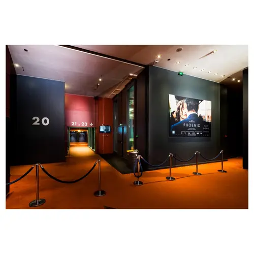 couloir intérieur cinéma moderne avec affiches et entrées de salles