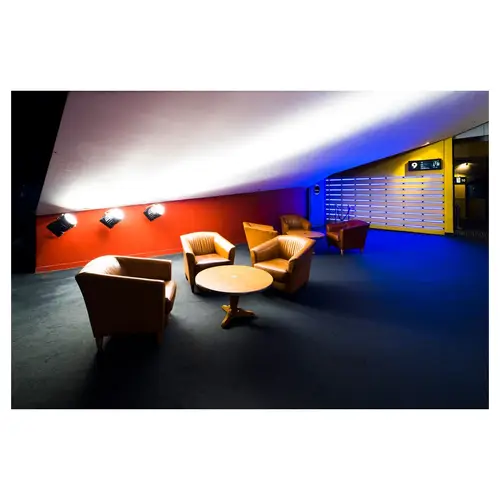 espace lounge dans un cinéma avec fauteuils et tables rondes