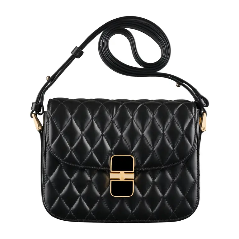 Photographie packshot d’un sac matelassé noir avec bandoulière et fermoir doré, fond blanc