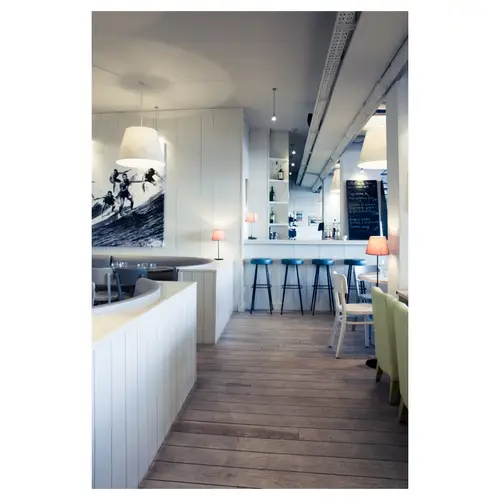 reportage restaurant biarritz intérieur bar moderne avec tabourets bleus et décoration surf