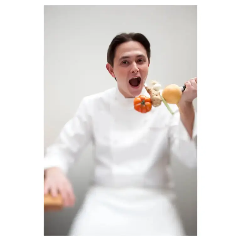 Chef cuisinier en action, brochette de légumes brandie prêt à croquer, sur un ton humoristique — plaquette de communication école ducasse.