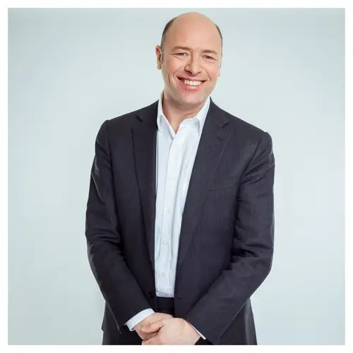 Portrait de dirigeant à Bordeaux, homme en costume sombre, sourire naturel.