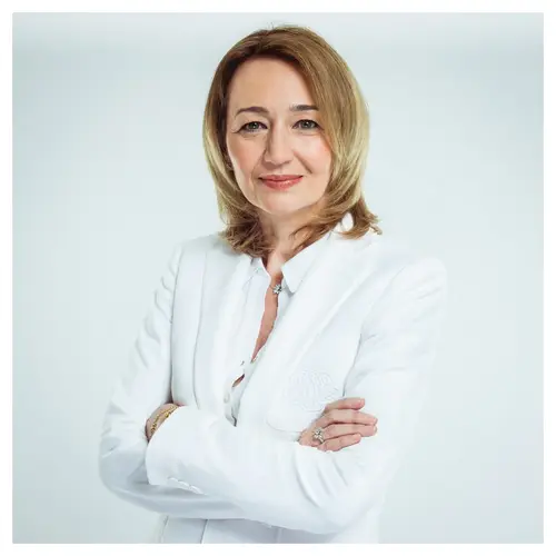 Portrait professionnel CV en studio d'une femme en blazer blanc, bras croisés.