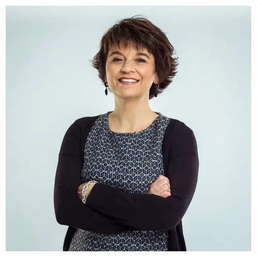 Portrait CV professionnel à Bordeaux d'une femme en robe à motifs, sourire discret.