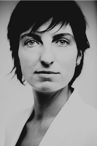 Portrait studio noir et blanc d’une femme, cadrage serré, regard face caméra, style éditorial minimal — photographe portrait à Bordeaux.