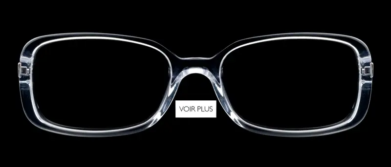 Photographie packshot produit de lunettes de vue transparentes en plastique cristal sur fond noir, réalisée par le studio photo Nicolas Louis à Dieulefit dans la Drôme. Bouton voir plus vers le portfolio e-commerce.