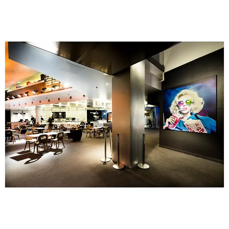 Photographie d'architecture corporate d'un espace lounge moderne avec œuvre pop art dans un cinéma à Paris.