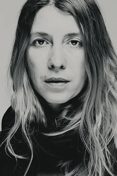 Portrait serré en noir et blanc d'une femme aux cheveux longs et ondulés, regard de face, réalisé en studio par Nicolas Louis photographe portraitiste dans la Drôme.
