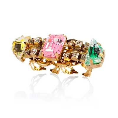 Photographe packshot d'un bijoux avec une bague multicolore, vue face, sur fond blanc, pour un shooting produit.
