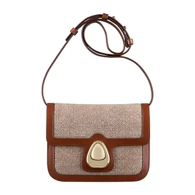 Photographie packshot d’un sac femme, bi matière avec boucle doée, vue face, sur fond blanc.