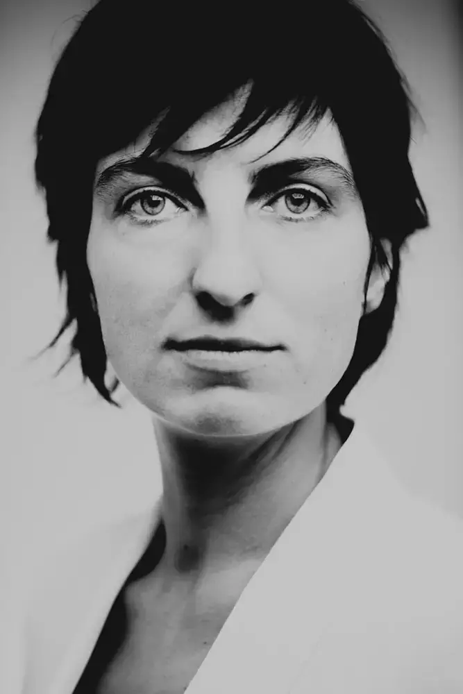 portrait noir blanc femme regard intense veste claire studio bordeaux