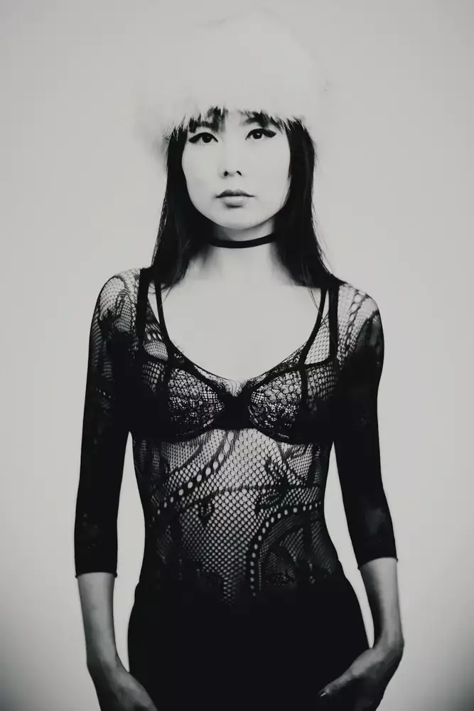 Portrait artistique en studio d’une femme portant un chapeau en fourrure, rendu noir et blanc.